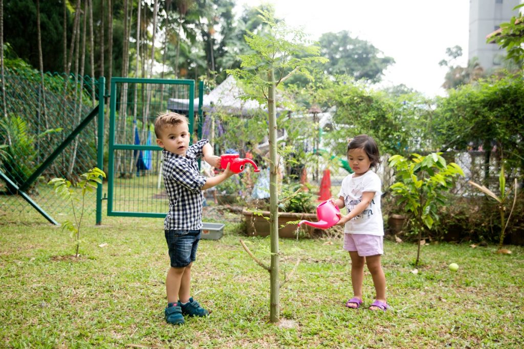 two children watering plants