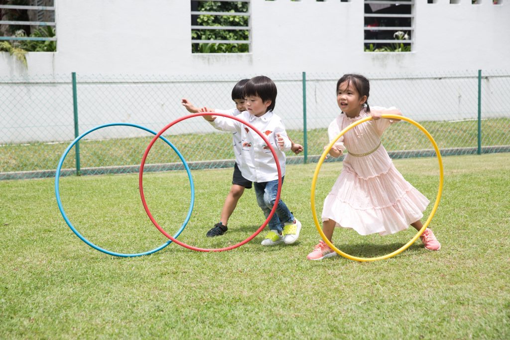 Kindergarten children playing hula hoops
