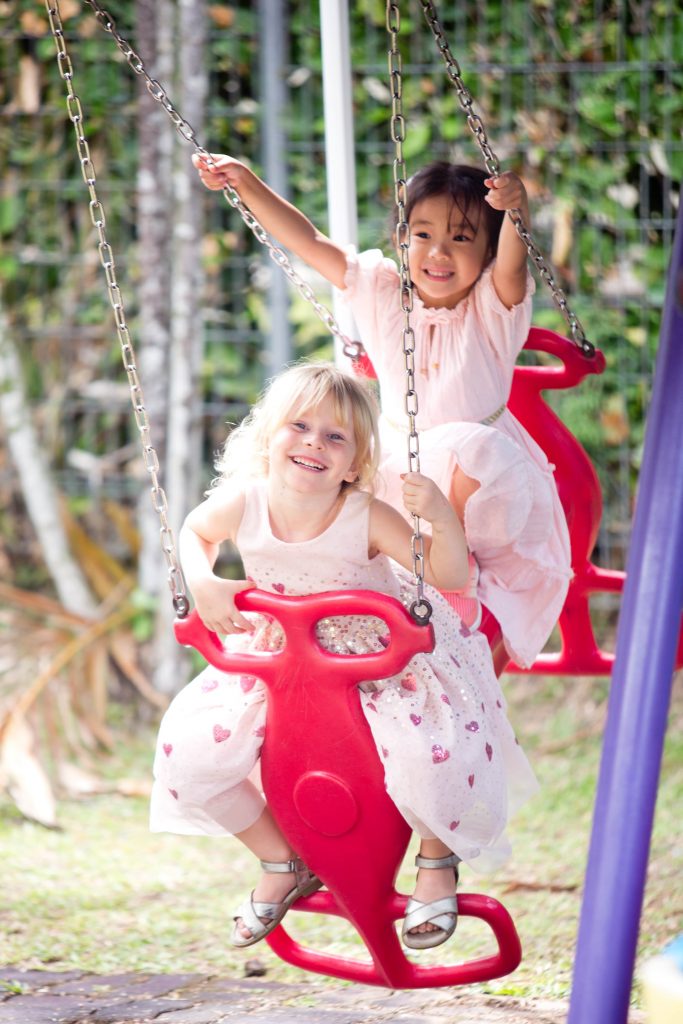 two preschoolers on a swing