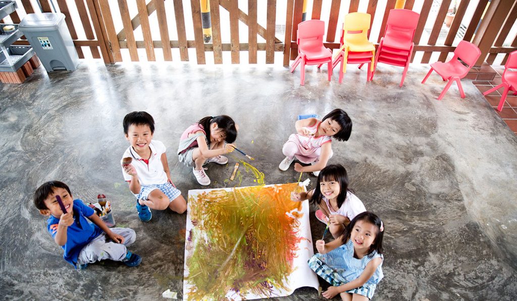 Children engaging in group painting activity