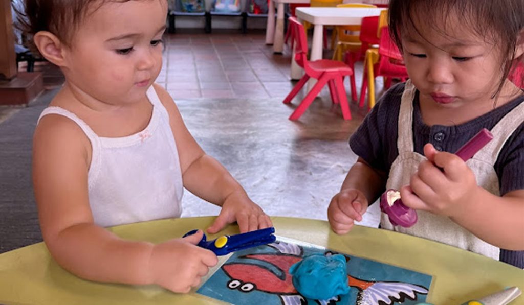 two preschoolers creating art
