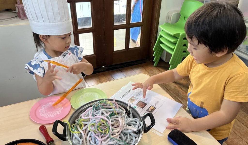 Two preschoolers in a pretend play session
