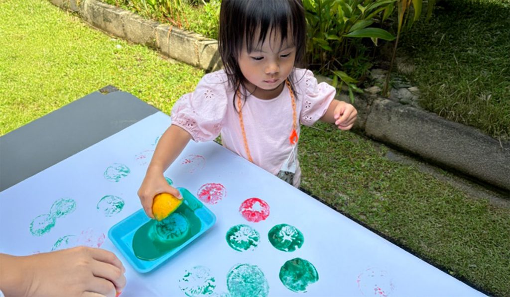preschooler using lemon to create art