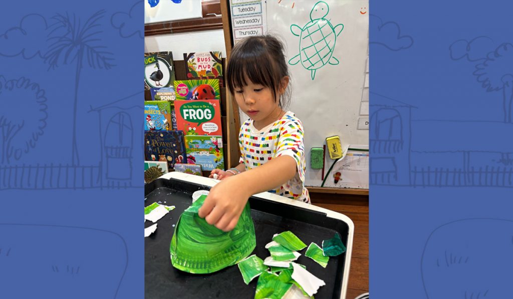 preschooler creating a paper hat
