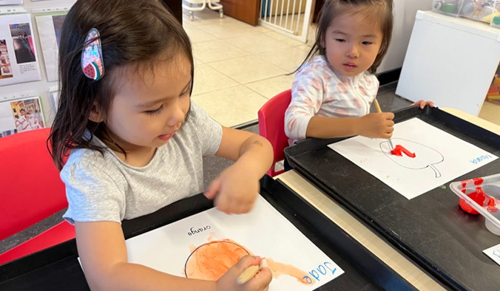 preschoolers colouring their artwork