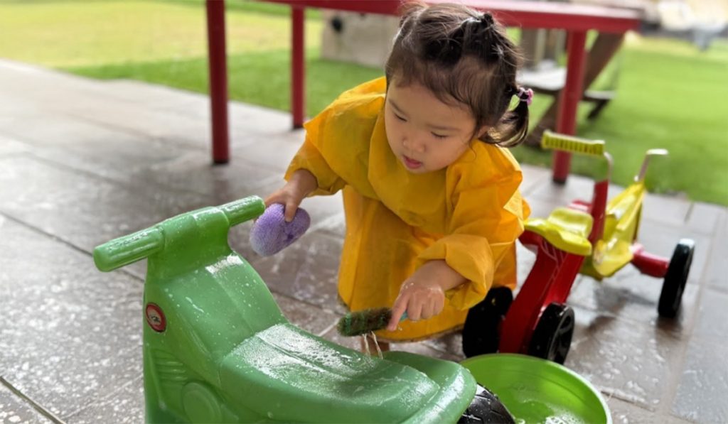 preschooler washing a toy car