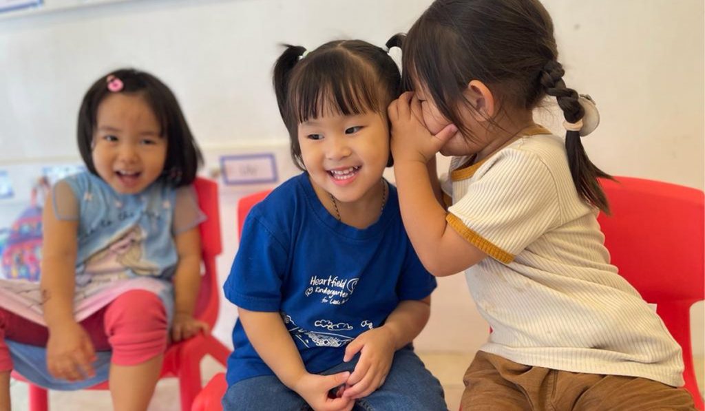Two preschoolers sharing a secret