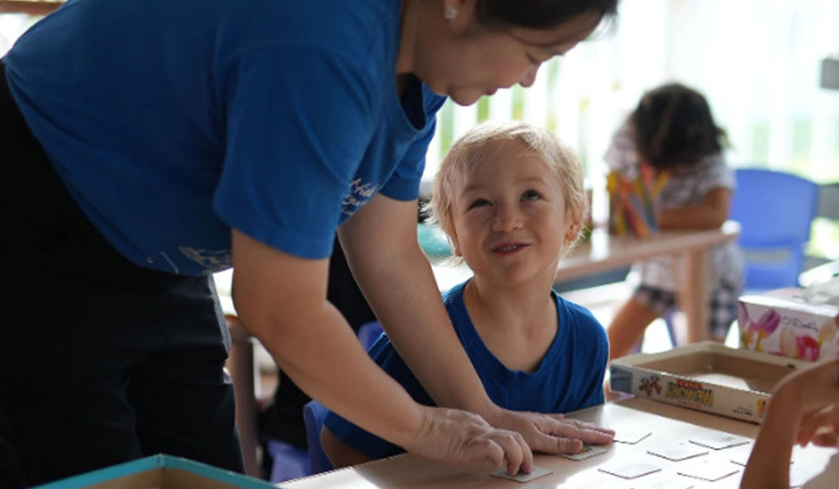 Preschool teacher helping